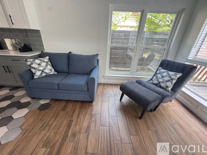 A living room with a blue couch and a matching chair.