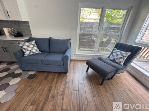 A living room with a blue couch and a matching chair.
