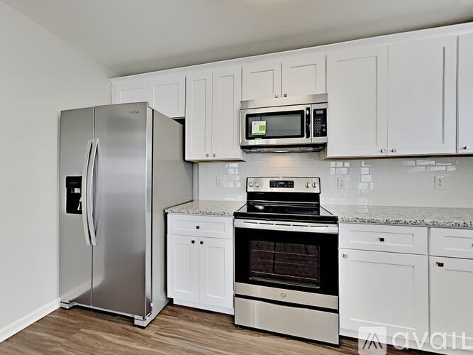 A kitchen with a stainless steel refrigerator, oven, and microwave.