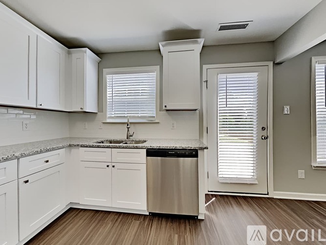 A kitchen with white cabinets and a granite countertop.