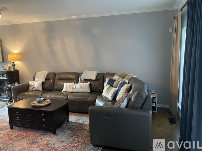 A living room with a brown leather couch and a coffee table.