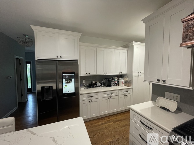 A modern kitchen with white cabinets and a marble countertop.