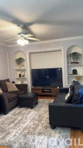 A living room with a black couch and a television.