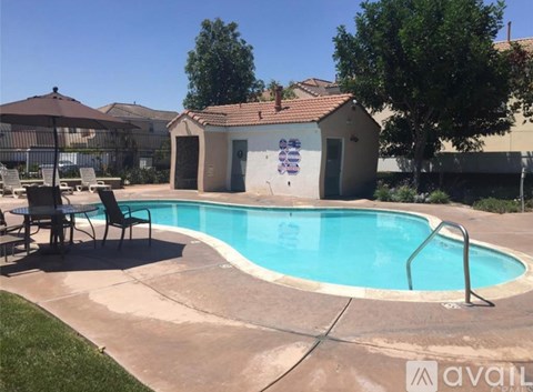 A small pool with a brown house and a tree in the background.