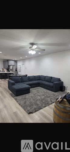 A living room with a grey sofa and a wooden barrel.