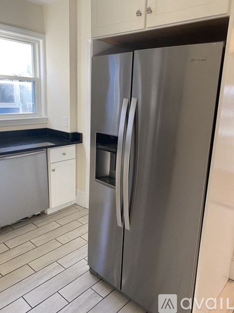 A Whirlpool refrigerator in a kitchen with tile flooring.