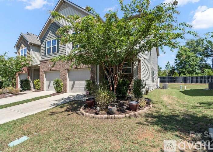 A house with a tree in front of it is for sale.