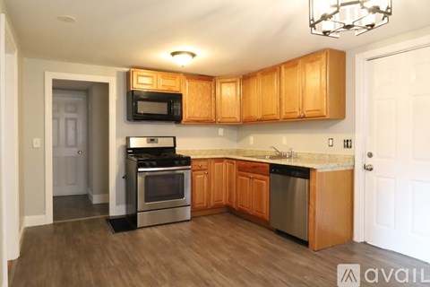 A kitchen with wooden cabinets and a black stove top oven.