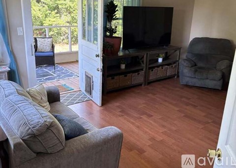 A living room with a grey couch and a television.