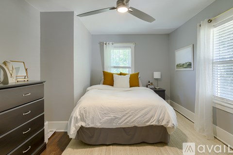 A bedroom with a bed, dresser, and window.