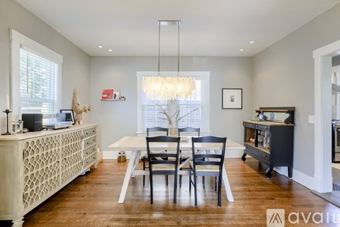 A dining room with a white table and chairs.