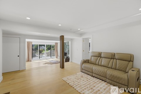 A living room with a tan couch and a white rug.