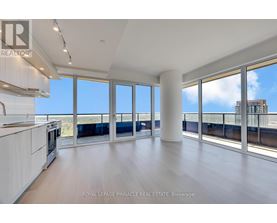 A spacious room with a view of the cityscape through large windows.