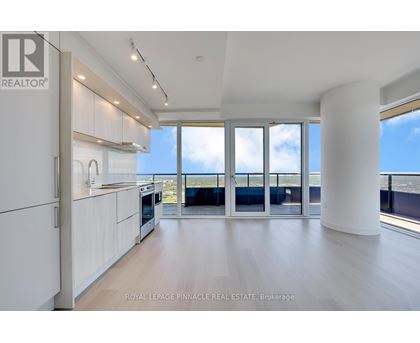 A spacious kitchen with white cabinets and a view of the ocean.