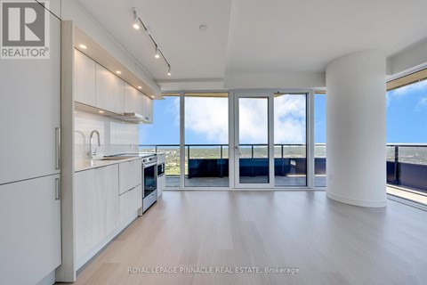 A spacious kitchen with white cabinets and a view of the ocean.