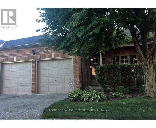 A house with two garages and a tree in front.