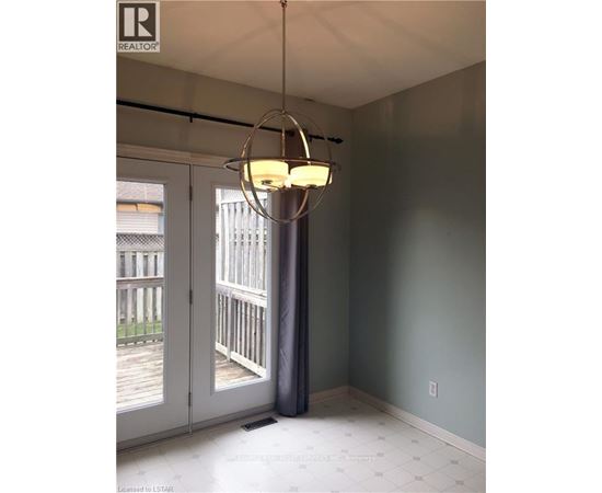 A room with a grey wall and a chandelier hanging from the ceiling.
