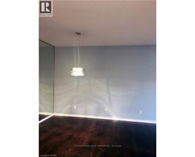 A room with a wooden floor and a light hanging from the ceiling.