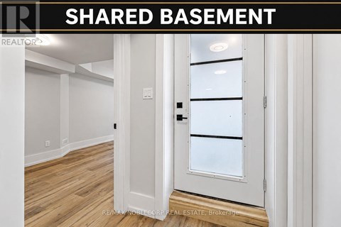 A white door with a glass window is in a room with wooden floors.