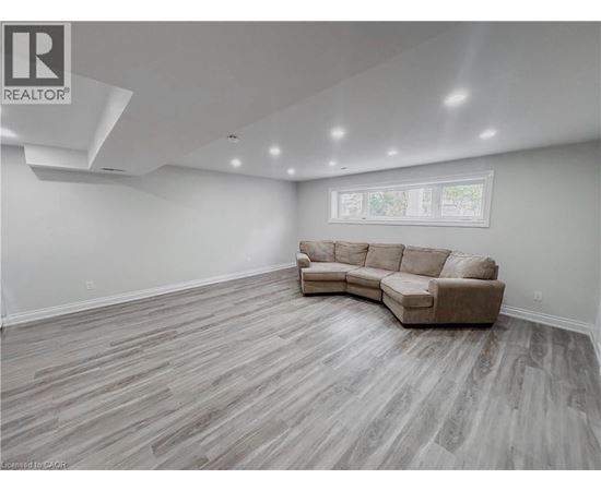 A spacious living room with a large sectional sofa and hardwood flooring.