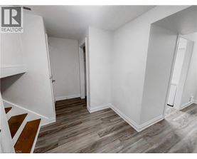 A room with wood flooring and white walls.