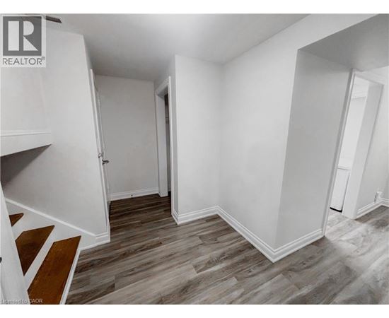 A room with wood flooring and white walls.