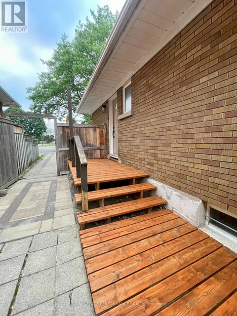 A wooden deck is in front of a brick building.