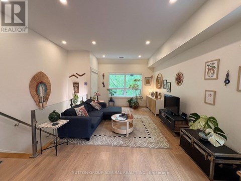 A living room with a dark blue couch and a wooden floor.