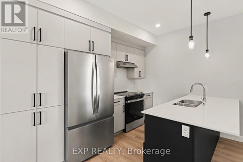 A modern kitchen with a stainless steel refrigerator and a white countertop.