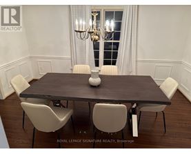 A dining room with a table and chairs.