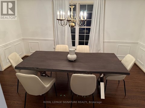 A dining room with a table and chairs.
