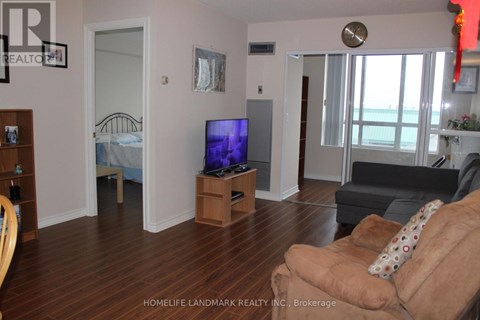 A living room with a brown couch and a flat screen TV.