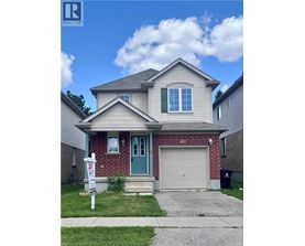 A house with a blue door and a garage door is for sale.