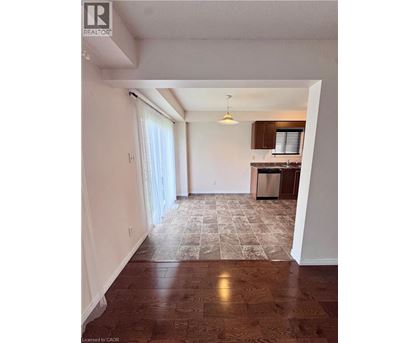 A room with a kitchen in the background and a tiled floor.