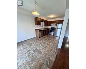 A kitchen with tile flooring and wooden cabinets.