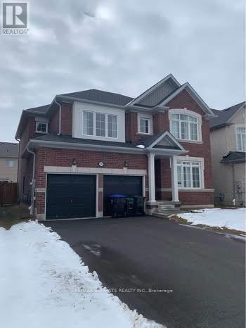 A large house with a garage is surrounded by snow.