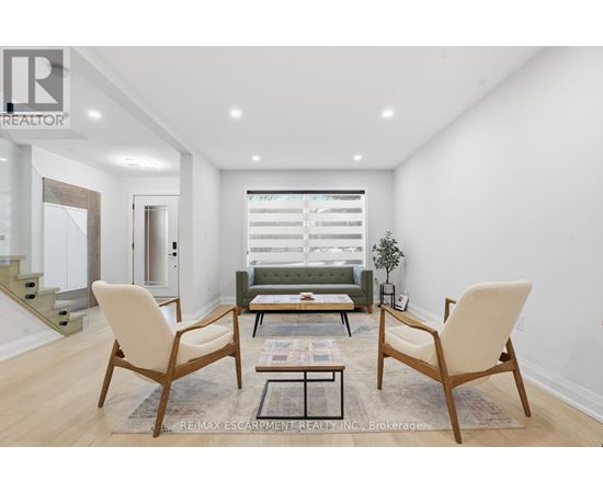 A living room with a sofa, two chairs and a coffee table.