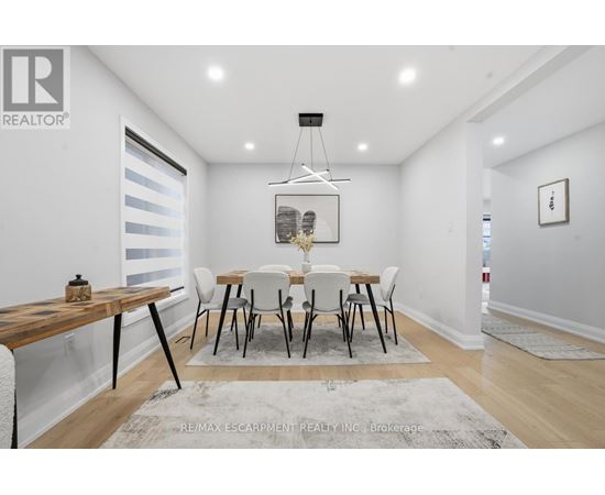 A dining room with a wooden table and chairs.