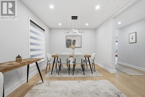 A dining room with a wooden table and chairs.