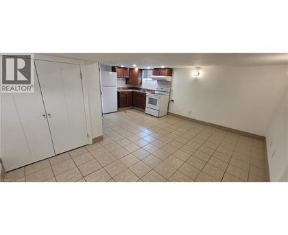 A kitchen area with a white refrigerator and cabinets.