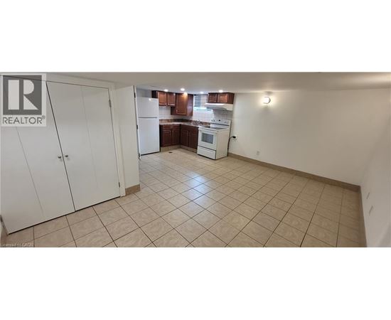 A kitchen area with a white refrigerator and cabinets.