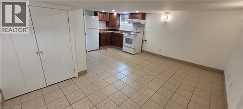 A kitchen area with a white refrigerator and cabinets.