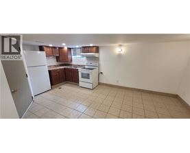 A kitchen with white appliances and brown cabinets.