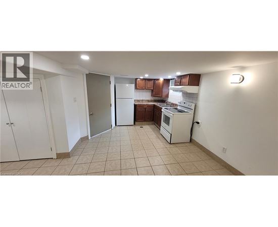 A kitchen with white appliances and brown cabinets.