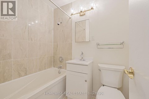 A white bathroom with a tub, toilet, and sink.