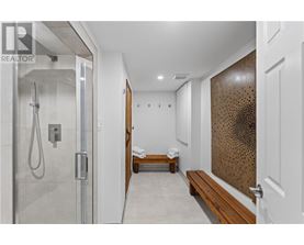 A modern bathroom with a walk-in shower and a bench.