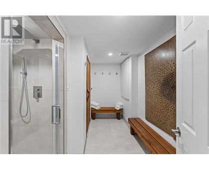 A modern bathroom with a walk-in shower and a bench.