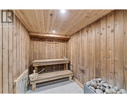 A wooden sauna with a bench and rocks.