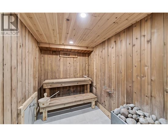 A wooden sauna with a bench and rocks.