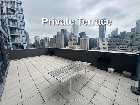 A private terrace with a table and chairs overlooking a city skyline.